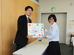 Handing the message board from the Peace Club to Nagasaki Mayor Taue (left)
