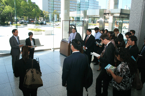 The group listens to an explanation of Hiroshima Peace Memorial Museum from the Museum's Deputy Director (left)
