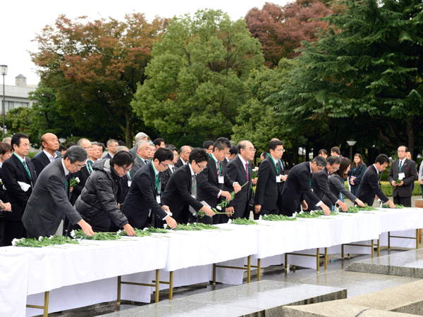 Participants paying respects and laying flowers at the Cenotaph for the A-Bomb Victims