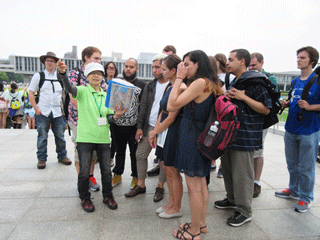 The group listens to an explanation by a peace volunteer at Peace Park