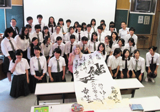 Intern receiving the calligraphy work praying for peace made by high school students