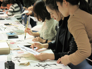International students from Asia trying Japanese calligraphy