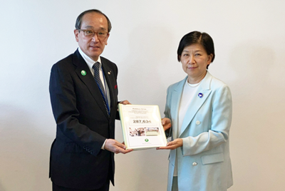 Ms. Nakamitsu (right) receiving the catalog of signatures