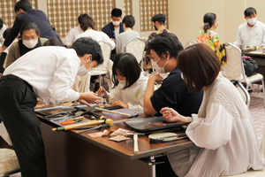 Visitors making origami cranes from copper sheets