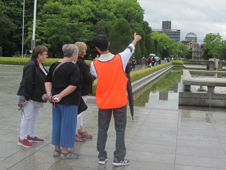 A youth peace volunteer guiding foreign tourists