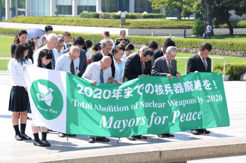 慰霊碑前で黙とうを捧げる参加者