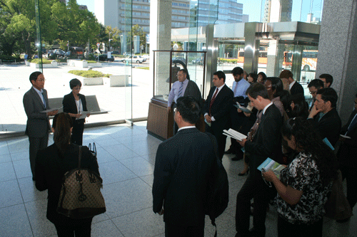 平和記念資料館について副館長から説明を受けるフェローズ一行
