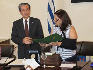 モンテビデオ市長にリーダー都市就任要請書を渡す小溝事務総長（左）