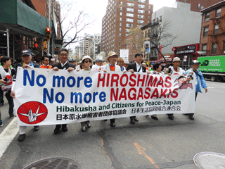 横断幕を持ち行進する日本被団協代表団と生協代表団