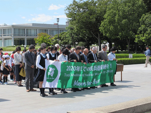 慰霊碑前で黙とうを捧げる参加者
