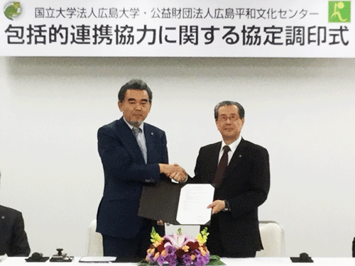 調印式で握手を交わす小溝理事長（右）と越智学長