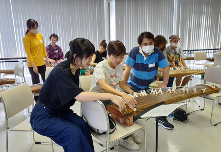 箏の演奏を一緒に楽しむベトナム人参加者（中央）と日本人参加者